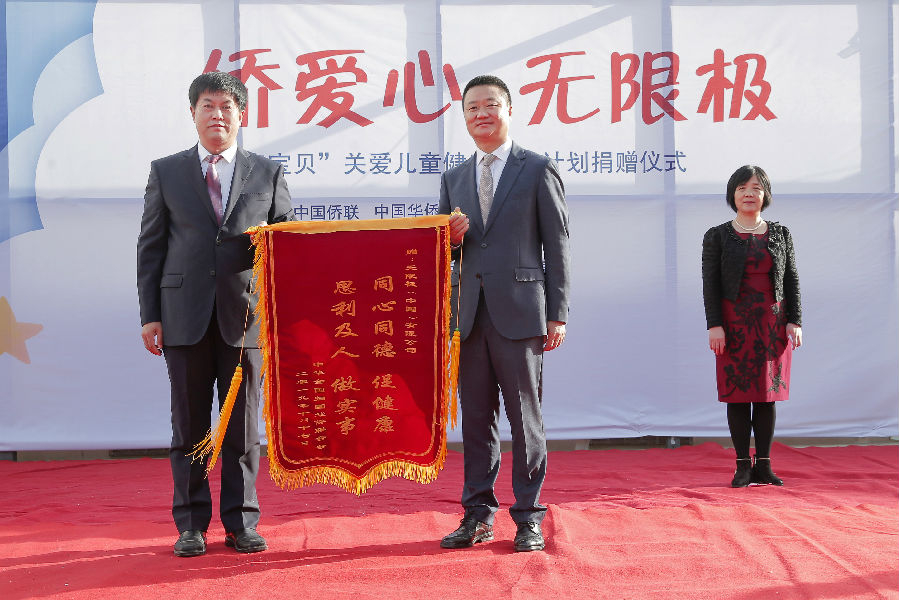 中国侨联刘景春副部长为无限极(中国)有限公司高级副总裁黄健龙赠送锦旗.jpg