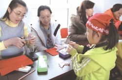 家长和孩子进社区学剪纸迎新春